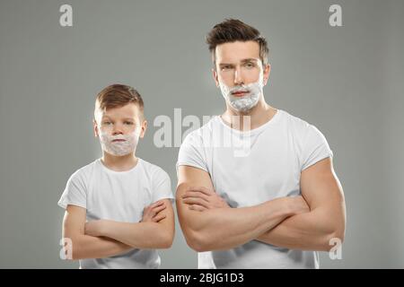 Padre e figlio rasano su sfondo chiaro Foto Stock