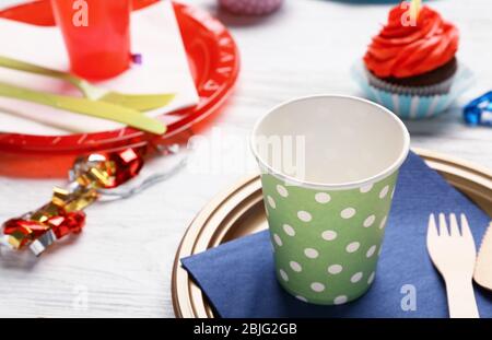 Piatto con cupcake di compleanno e tazza su tavolo di legno Foto Stock