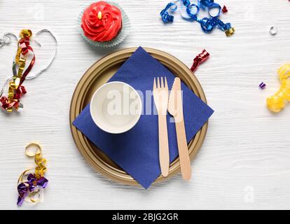 Piatto con cupcake di compleanno e tazza su tavolo di legno Foto Stock