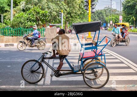 New Delhi / India - 19 settembre 2019: Autista seduto sul suo risciò in bicicletta per le strade di Nuova Delhi, India Foto Stock