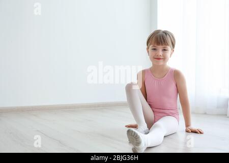 Bella ballerina seduta a pavimento in sala da ballo Foto Stock