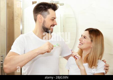 Coppia giovane spazzolare i denti in bagno Foto Stock