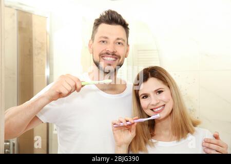 Coppia giovane spazzolare i denti in bagno Foto Stock