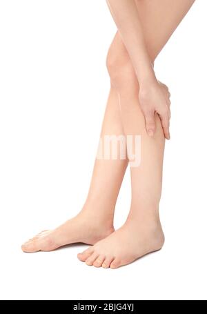 Giovane donna che soffre di dolore alle gambe su sfondo bianco Foto Stock