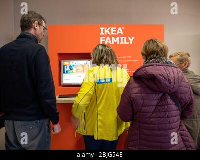 Parigi, Francia - 9 dicembre 2017: Vista posteriore delle persone di fronte al chiosco digitale presso il negozio IKEA che genera la nuova tessera per famiglie IKEA Foto Stock