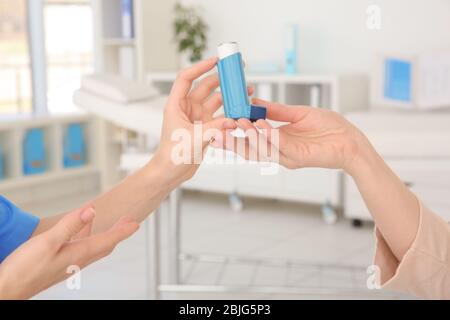 Medico che dà inalatore donna adulto in clinica Foto Stock