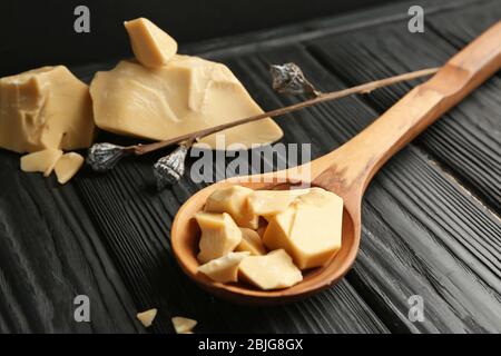 Cucchiaio di legno con burro di cacao in tavola Foto Stock