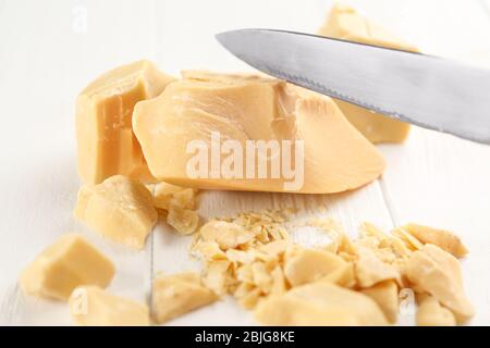 Burro di cacao e coltello su sfondo di legno Foto Stock