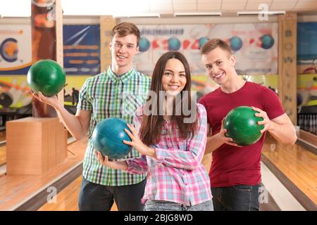 Amici felici che giocano insieme a bowling Foto Stock