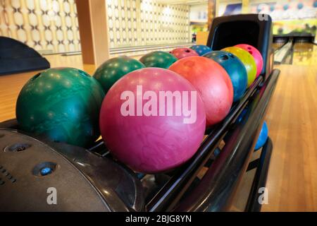 Palline da bowling colorate nella macchina di ritorno Foto Stock