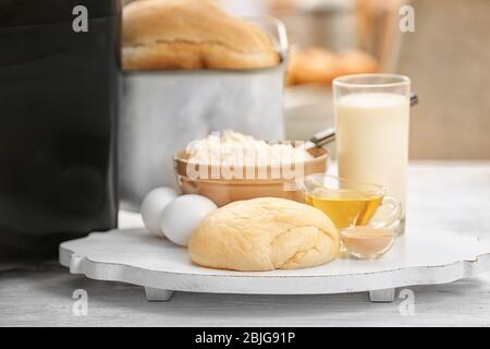 Asse di legno con macchina per la pasta e il pane a tavola Foto Stock