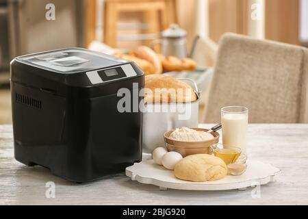 Asse di legno con macchina per la pasta e il pane a tavola Foto Stock