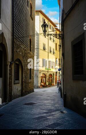 Un vicolo oscuro, quasi vuoto, verso una trattoria cafè nel centro storico medievale e rinascimentale di Firenze, in Toscana Foto Stock