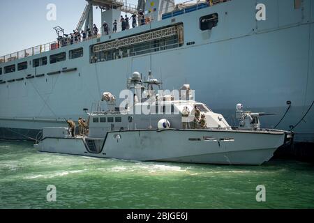 MANAMA, Bahrain (24 aprile 2020) UNA pattuglia Mark VI, assegnata alla Commander Task Force (CTF) 56, affianca la Royal Fleet Auxiliary Landing Boat RFA Cardigan Bay (L3009) per eseguire un rifornimento simulato in mare attraverso il rafting in porto, aprile 24. CTF 56 è responsabile della pianificazione e dell'esecuzione di missioni di spedizione, incluse le operazioni sulle rivierasche costiere nell'area operativa della 5th Fleet negli Stati Uniti. (STATI UNITI Foto Navy di Mass Communication Specialist 1a Classe Kory Alsberry) Foto Stock