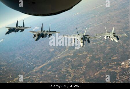 Aerei della U.S. Air Force F-15 aerei da combattimento della 104a Fighter Wing della Massachusetts Air National Guard e dei Royal Canadian Air Force CF-18 aerei da combattimento della 3 Wing, Bagotville, Quebec si unirà dietro una Maine Air National Guard KC-135 Stratotanker dalla 101esima Ala di rifornimento aereo durante una dimostrazione transfrontaliera della North American Aerospace Defence Command Region e della Canadian NORAD Region, 23 aprile 2020. L'equipaggio e i membri della Air National Guard e della Royal Canadian Air Force hanno esercitato abilità tattiche di intercettazione in un esercizio di difesa aerea progettato per rafforzare l'interoperabilità in tutta la Foto Stock