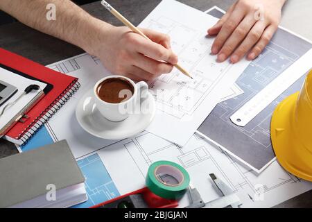 Tecnico che lavora a tavola con disegni Foto Stock