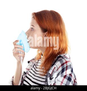 Giovane donna che usa il nebulizzatore per asma e malattie respiratorie su fondo bianco Foto Stock