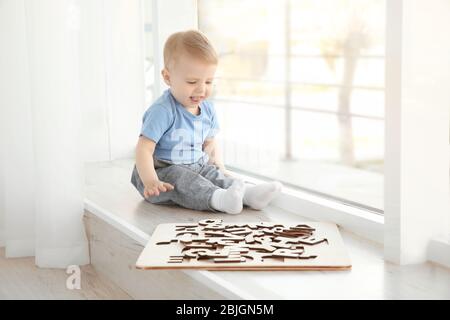 Carino bambino che gioca con le lettere a casa Foto Stock