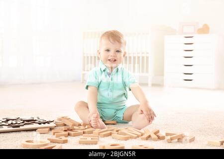 Carino bambino che gioca con le lettere a casa Foto Stock