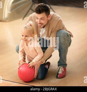 Famiglia che si diverte al bowling club Foto Stock