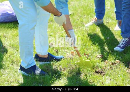 Gruppo di volontari che lavorano nel parco durante la giornata di sole Foto Stock