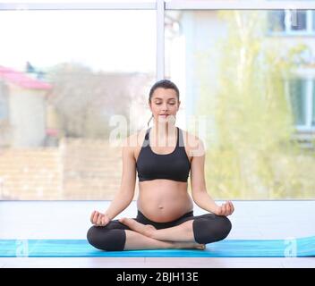 Giovane donna incinta allenarsi in palestra. Concetto di salute Foto Stock