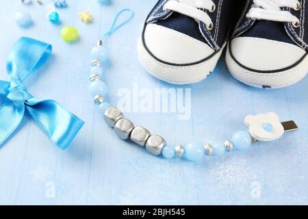 Composizione del clip per succhietto per bambino, scarpe e nodo di prua sul tavolo Foto Stock