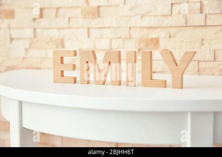 Nome del bambino EMILY composto di lettere di legno sulla tavola. Scelta del concetto di nome Foto Stock