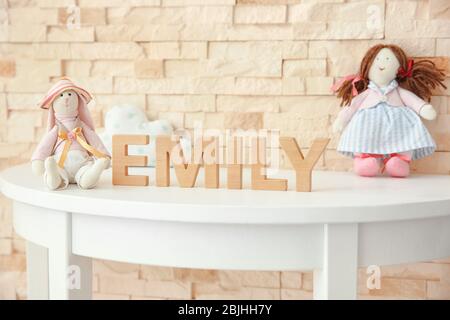 Nome del bambino EMILY composto di lettere di legno sulla tavola. Scelta del concetto di nome Foto Stock