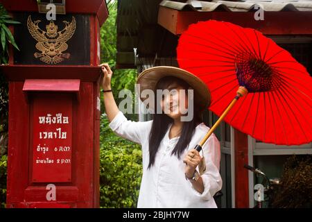 RATCHABURI, THAILANDIA - SETTEMBRE 24 : viaggiatori donne thailandesi indossare abiti etnici vietnamiti stile con cappello di bambù e ombrello rosso per scattare foto in gar Foto Stock