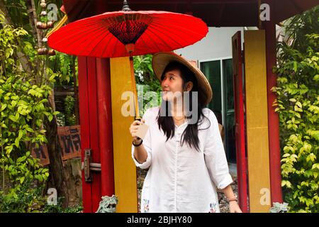 RATCHABURI, THAILANDIA - SETTEMBRE 24 : viaggiatori donne thailandesi indossare abiti etnici vietnamiti stile con cappello di bambù e ombrello rosso per scattare foto in gar Foto Stock