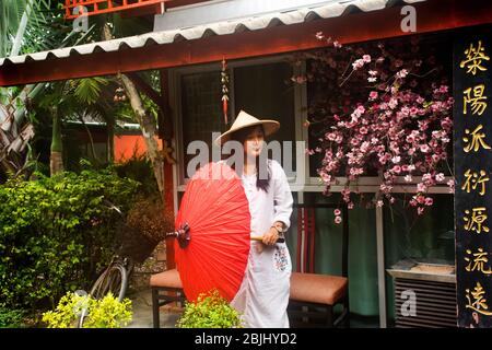 RATCHABURI, THAILANDIA - SETTEMBRE 24 : viaggiatori donne thailandesi indossare abiti etnici vietnamiti stile con cappello di bambù e ombrello rosso per scattare foto in gar Foto Stock