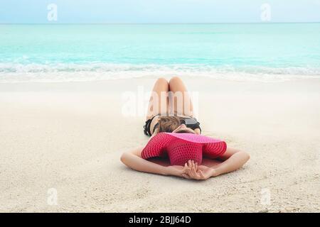 Bella giovane donna che si trova sulla spiaggia del resort Foto Stock