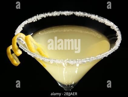 Bicchiere di limone goccia martini con scorza su fondo nero Foto Stock