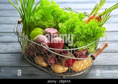 Barbabietole fresche con verdure in cestino di metallo a tavola Foto Stock