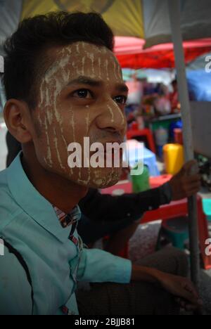 Uomo con pasta di Thanaka sul suo volto, Yangon, Myanmar (Birmania), Asia sudorientale. Foto Stock