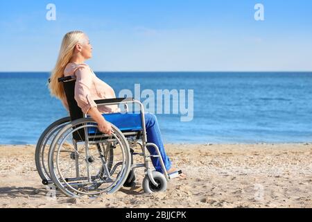 Donna anziana in carrozzina sulla costa marina Foto Stock