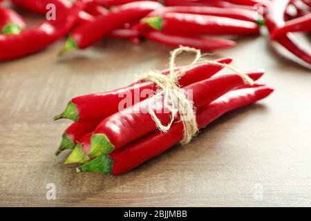 Peperoncino rosso legato su tavolo di legno Foto Stock