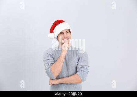 Bell'uomo in cappello di Natale su sfondo chiaro Foto Stock