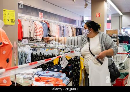 Berlino, Germania. 29 aprile 2020. Un cliente che indossa una maschera facciale seleziona i vestiti in un negozio a Berlino, capitale della Germania, il 29 aprile 2020. Berlino ha reso obbligatorio nei negozi il mercoledì, in quanto l'obbligo di coprire bocca e naso è già in vigore per i trasporti pubblici da lunedì. Credit: Binh Truong/Xinhua/Alamy Live News Foto Stock