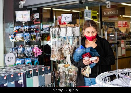 Berlino, Germania. 29 aprile 2020. Una donna che indossa una maschera lascia un negozio a Berlino, capitale della Germania, il 29 aprile 2020. Berlino ha reso obbligatorio nei negozi il mercoledì, in quanto l'obbligo di coprire bocca e naso è già in vigore per i trasporti pubblici da lunedì. Credit: Binh Truong/Xinhua/Alamy Live News Foto Stock