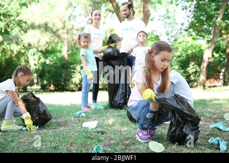 Giovani volontari e bambini che raccolgono rifiuti nel parco Foto Stock
