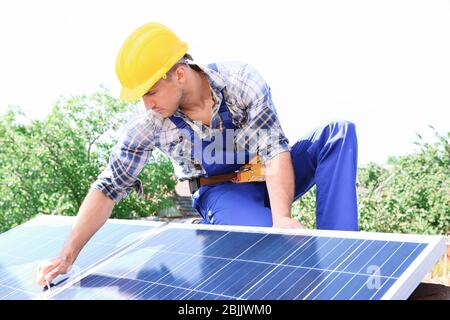 Lavoratore che installa pannelli solari all'aperto Foto Stock