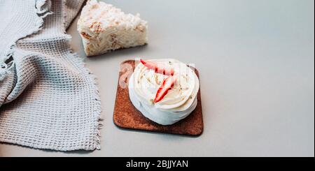 Banner di cottura. Pasticceria di souffle bianco con crema e fragole fresche sul tavolo luminoso della cucina con salvietta di waffle Foto Stock