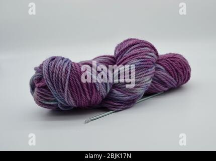 Matassa o palla di lana o filato viola tinto a mano e filato a mano in studio girato con sfondo bianco Foto Stock