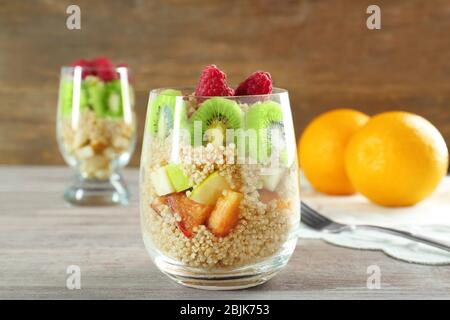 Quinoa e frutta in vetro sul tavolo Foto Stock