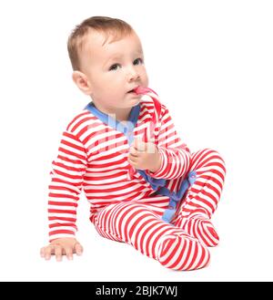 Bambino carino con canna da zucchero su sfondo bianco. Concetto di Natale Foto Stock