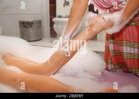 Donna con massaggio in schiuma in hammam Foto Stock