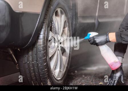 Un uomo di pulizia interni auto da utilizzare schiuma chimica e macchina di  lavaggio Foto stock - Alamy