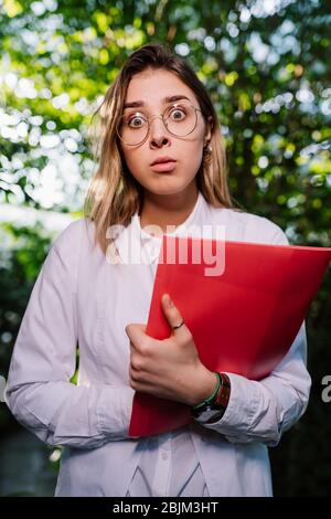 Giovane ingegnere agricolo che lavora in serra. Giovane scienziata femminile che guarda la macchina fotografica Foto Stock